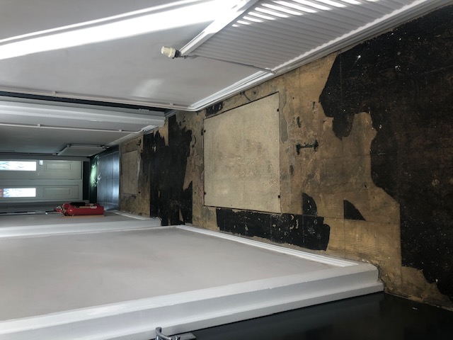 Before: A view of the entrance corridor with tiles that needed removing. Removal was not started until a local company checked for asbestos.